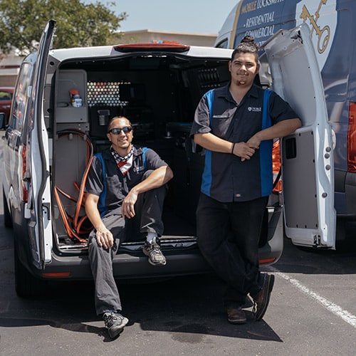 Noble Locksmith employees posing at the back of their locksmith van